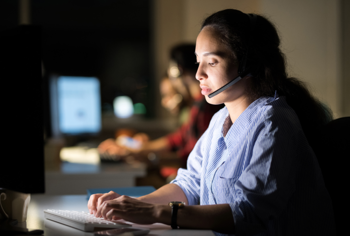 Woman at call center typing on computer